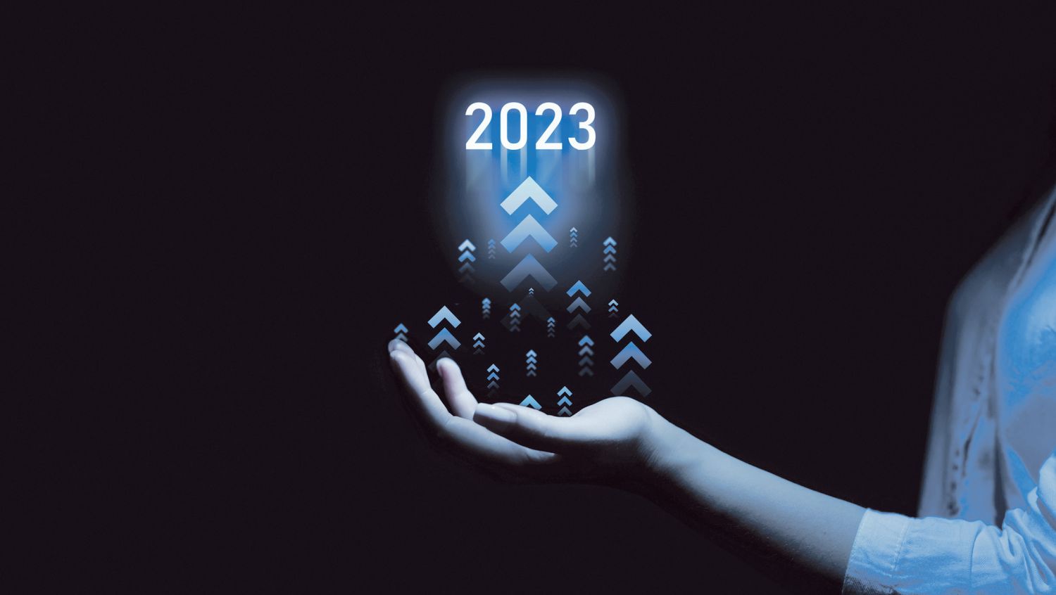 Eine Hand hält ein virtuelles Symbol für 2023 und Pfeile, die aufwärts zeigen